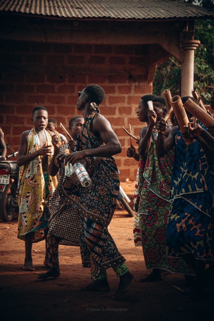 Danseuses et danseurs en pagnes colorés lors d'une cérémonie en plein air